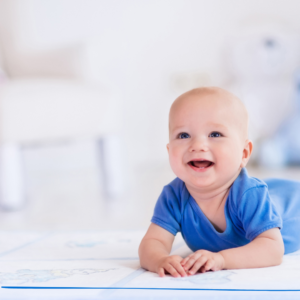 happy baby on their belly smiling at the pediatric chiropractic office waiting on a appointment