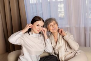 Senior woman and young woman looking happy and showing off gifts to camera