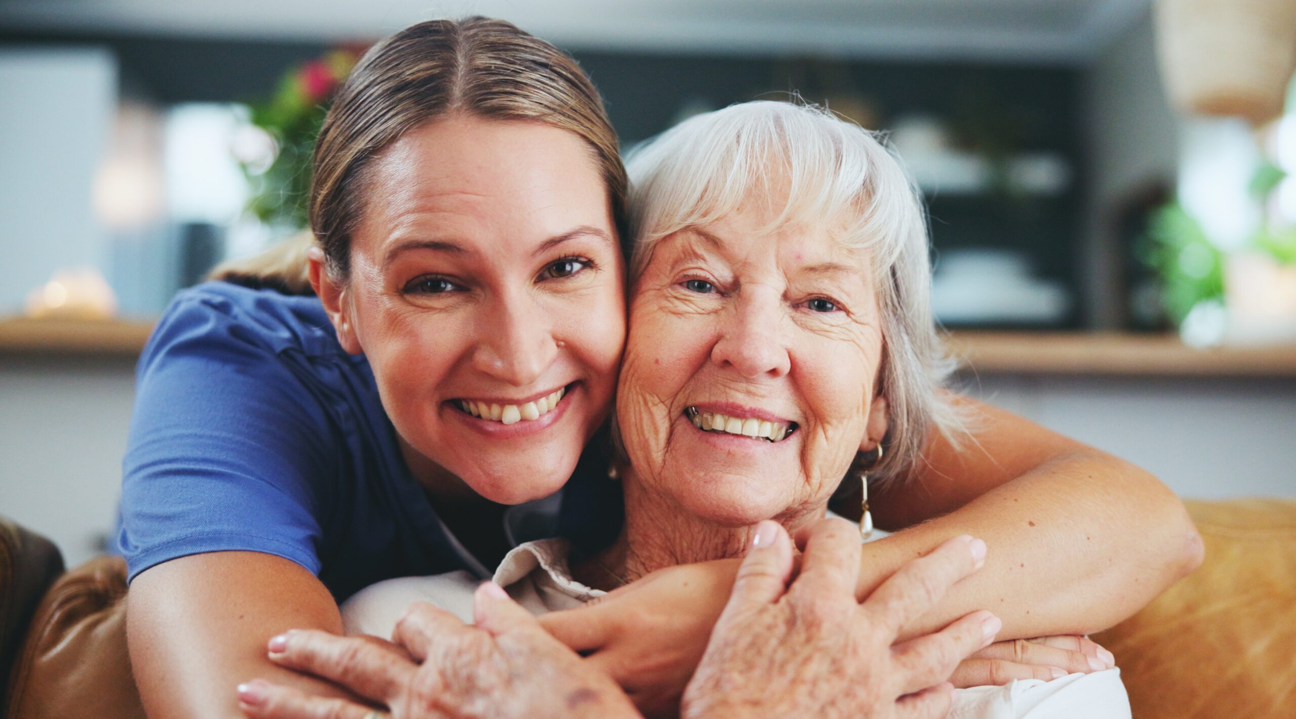 senior woman and young brunette woman hugging facing the camera 